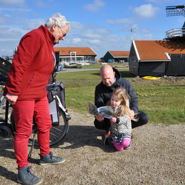 Burgemeester Sebastiaan Nieuwland van Uitgeest bekijkt met zijn dochter Julia het nieuwe routeboekje