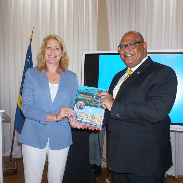 Minister Cooper uit Curaçao krijgt uit handen van Luzette Kroon het boek